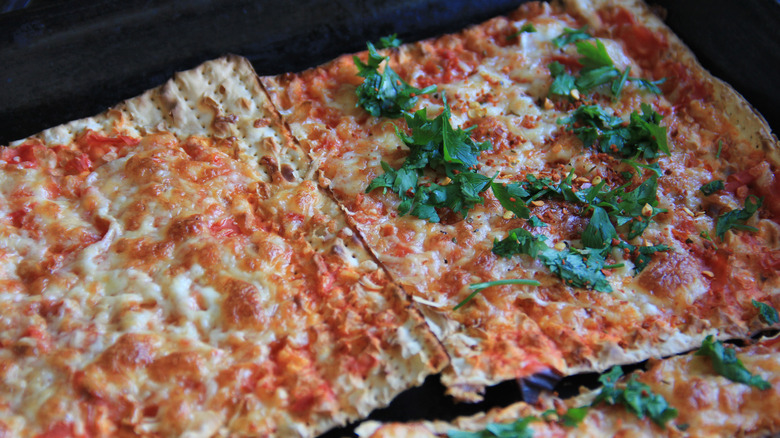 Matzo brei sits in a white bowl with a fork on the wide rim