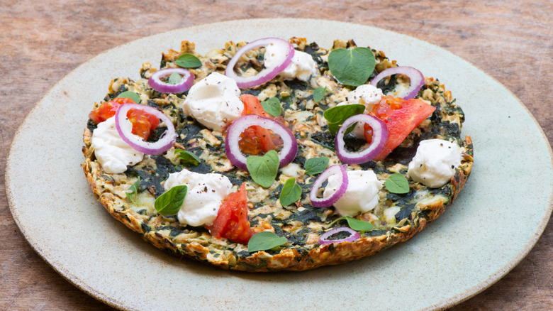 Matzo brei topped with labneh, tomato, red onion, and fresh basil