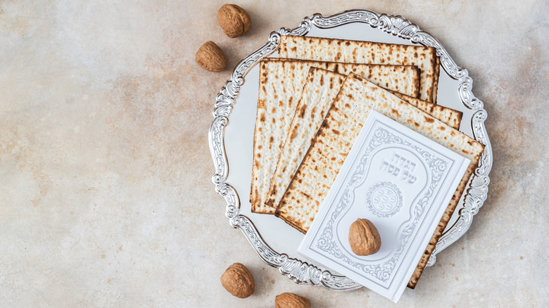 Matzo and walnuts on a plate with a Haggadah.