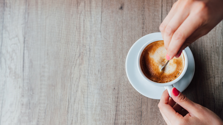 Person mixing coffee