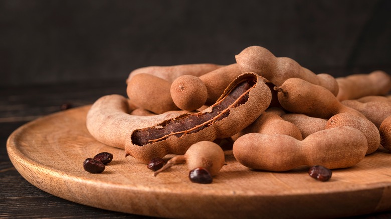 Tamarind pods on a wooden plate 