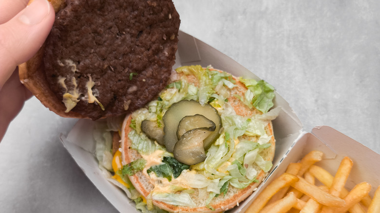 disassembled Big Mac revealing sauce in its container.