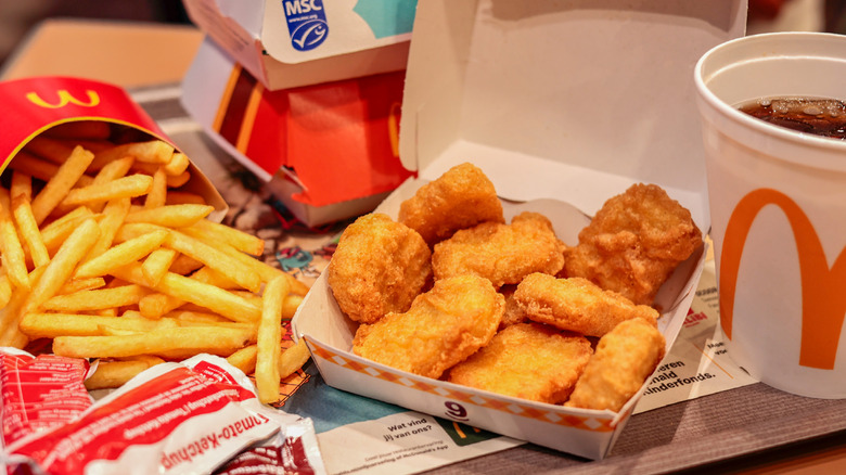 A McDonald's chicken nugget meal with fries and a small drink sit open on a table