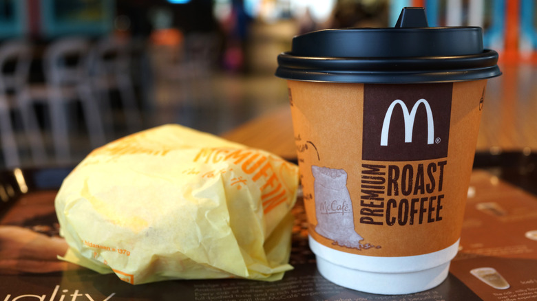A McMuffin and McCafe coffee sit on a table.