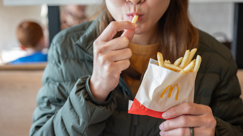 A customer eats McDonald's fries.
