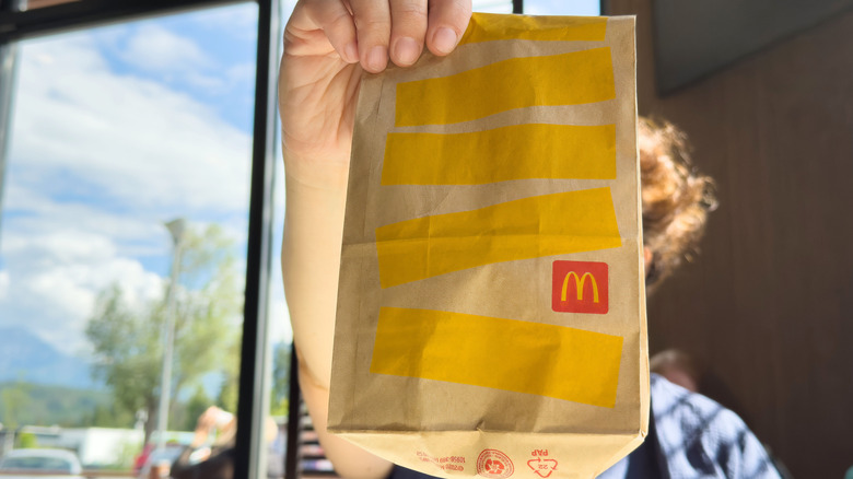 A diner holds up a McDonald's bag.