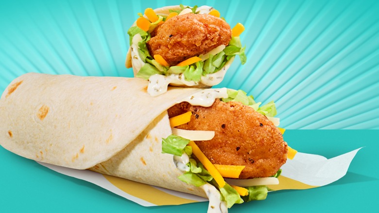 Chicken wraps from McDonald's sit against a teal backdrop