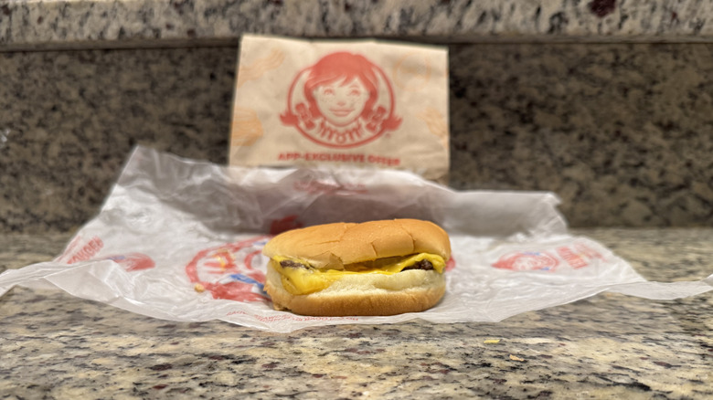 Jr. Cheeseburger in Wendy's wrapper on counter.