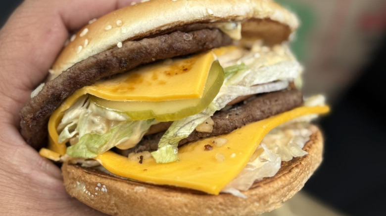A hand holds a McDonald's burger