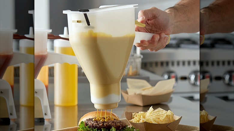 A mustard dispenser sits against a gray background.