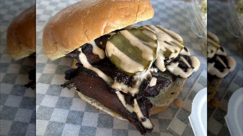 A meat mushroom burger topped with burger sauce and sliced pickles