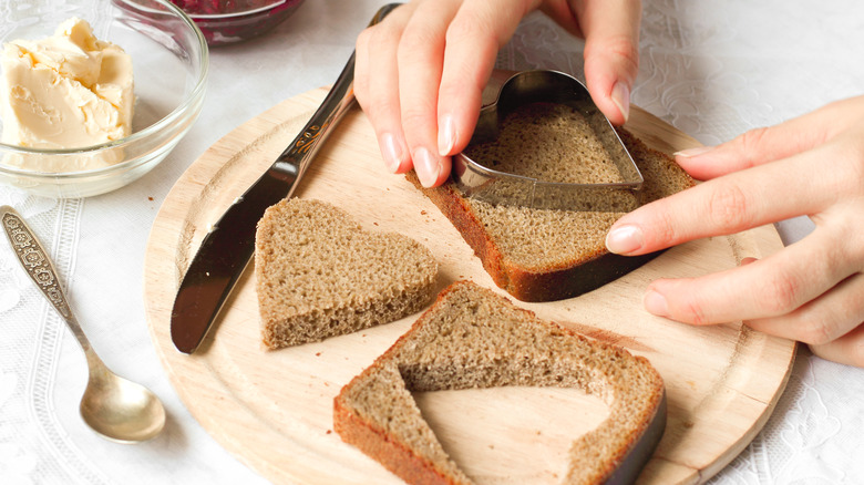 Person cutting out heart shapes in bread