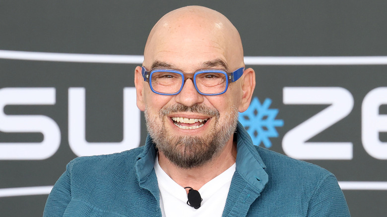 Michael Symon wearing blue glasses and smiling at event