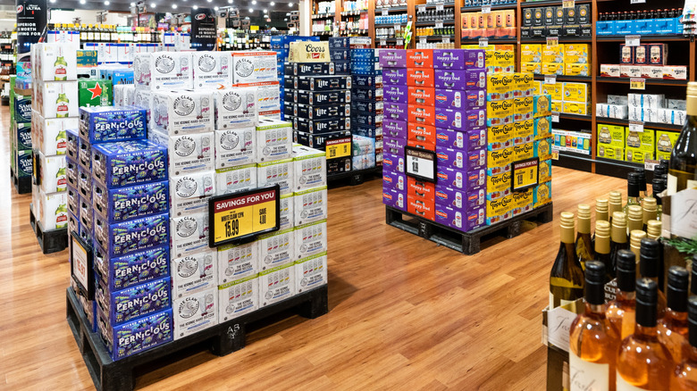 Cases of hard seltzer sit on a store floor.