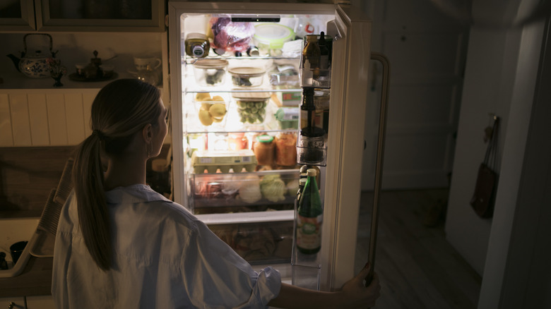 Woman looking inside refrigerator