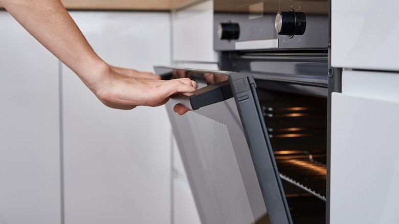 hands opening opening oven door