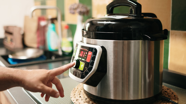 timer on instant cooker, finger pressing it