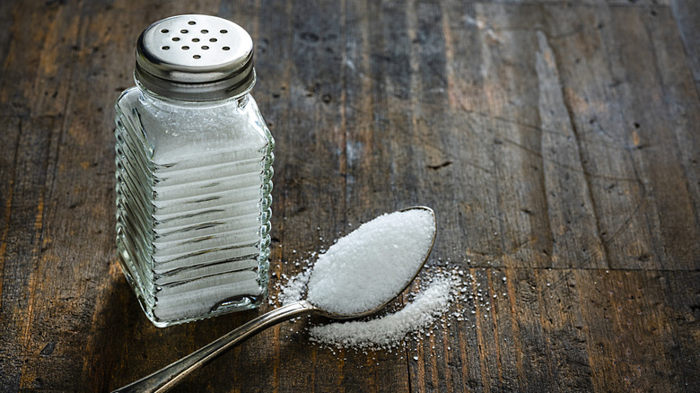 salt shaker and spoon on wooden table