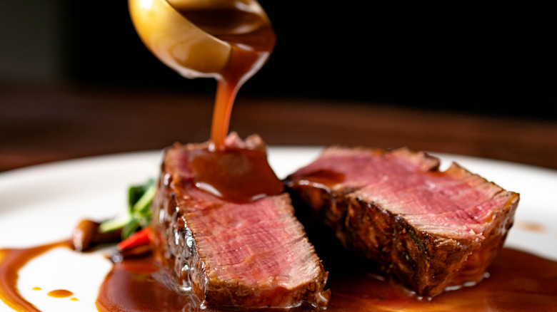 pouring sauce over steak