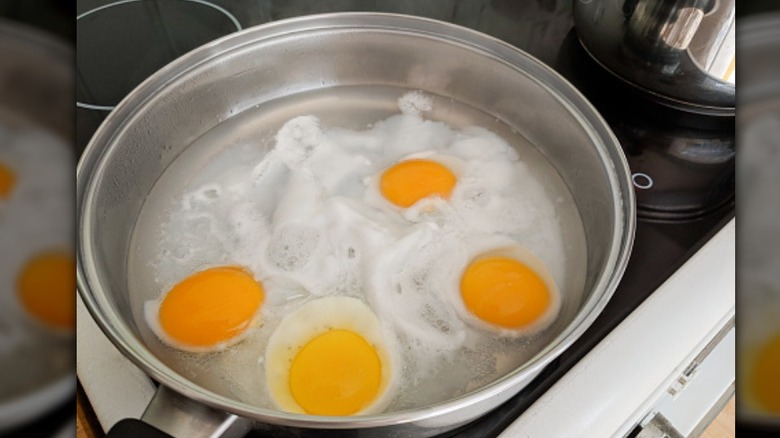 four poached eggs in water