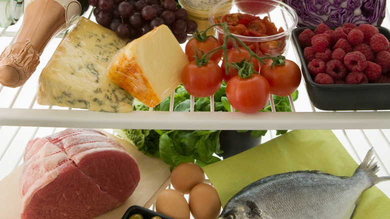 fridge filled with groceries, including raw meat
