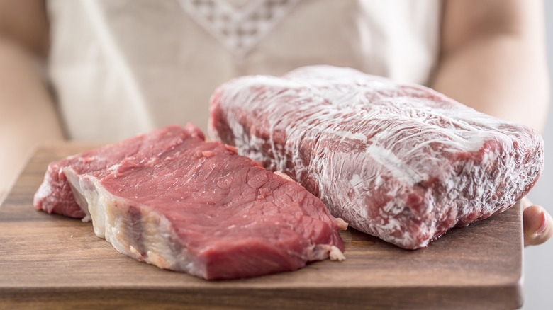 cutting board with raw and frozen meat