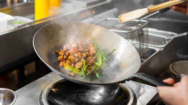 meat and vegetables stirred in a wok