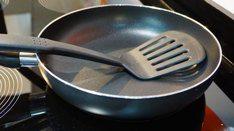 Non-stick pan on stove with plastic spatula