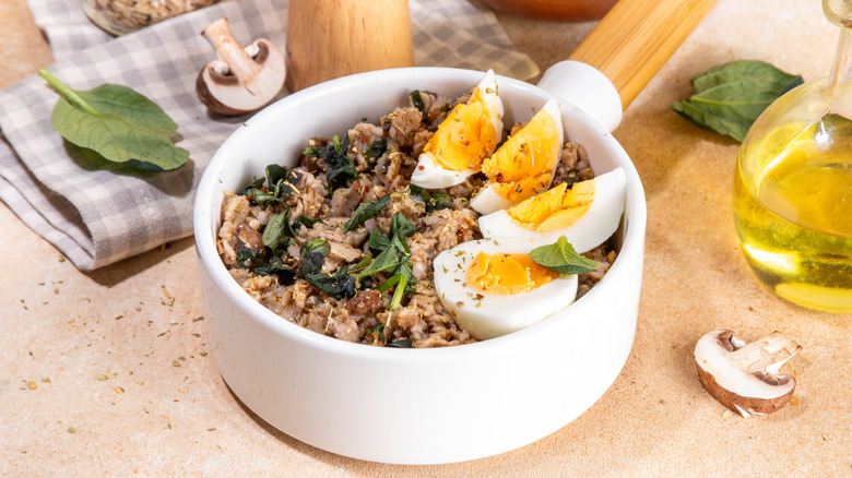 Overnight oats topped with eggs and fresh herbs next to slices of mushroom