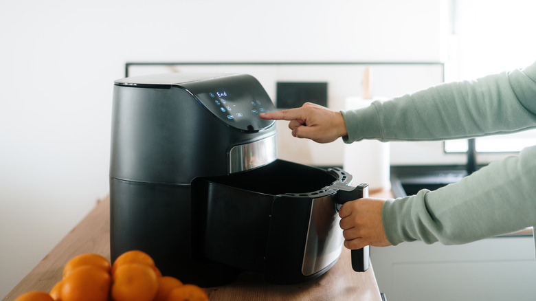 hands setting air fryer settings