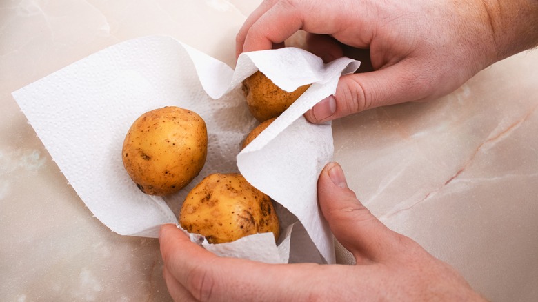 hands drying raw potatoes
