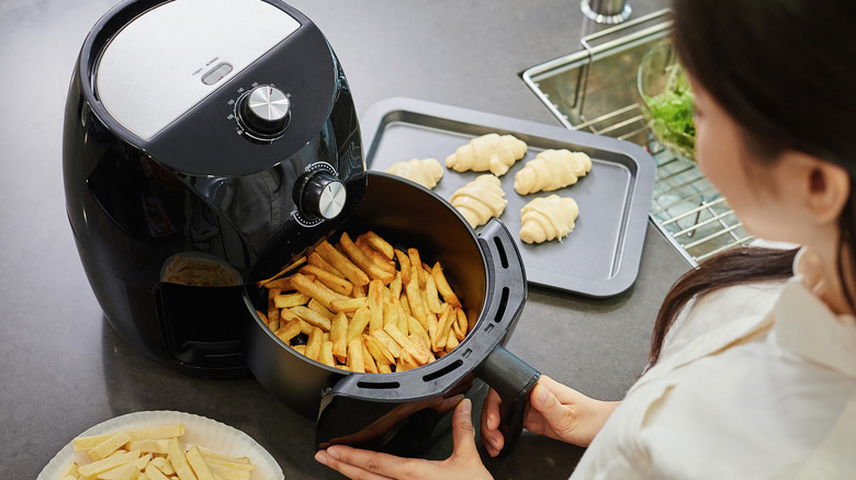 extracting air fryer basket of fries