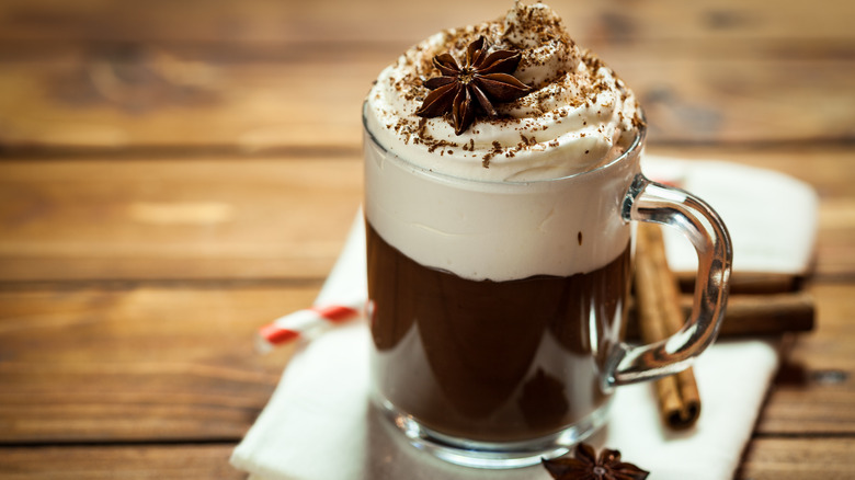 Mocha in clear mug with chocolate syrup and whipped cream