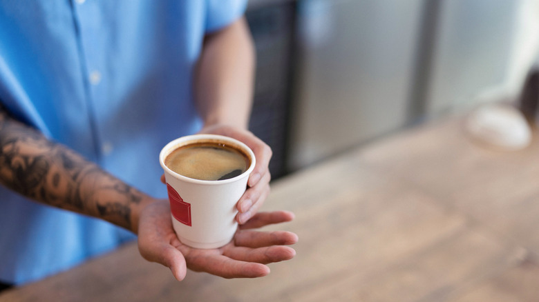 Barista serves a cup of coffee.