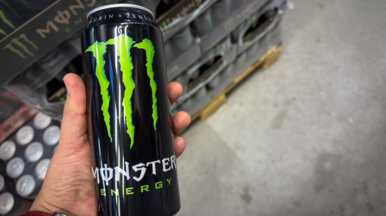 Monster drink held in hand.