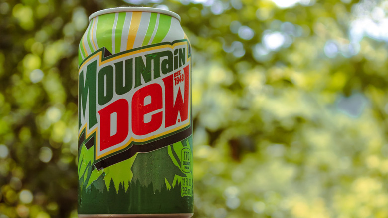A can of Mountain Dew sits on a dewy mountain background