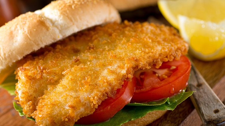 Crispy fried fish on a bun with lettuce and tomato
