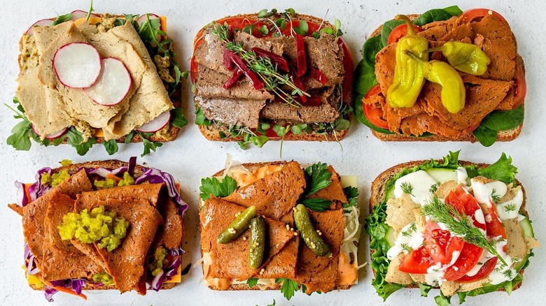 Open-faced sandwiches with different vegetarian deli slices and veg