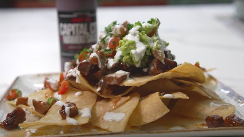 beef nachos topped with guacamole and mumbo sauce