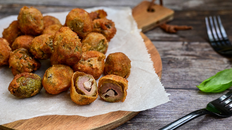 Olive ascolane on a parchment lined wooden serving board