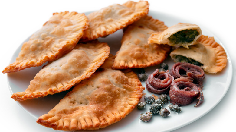 A white plate of Panzerotti with anchovies and capers