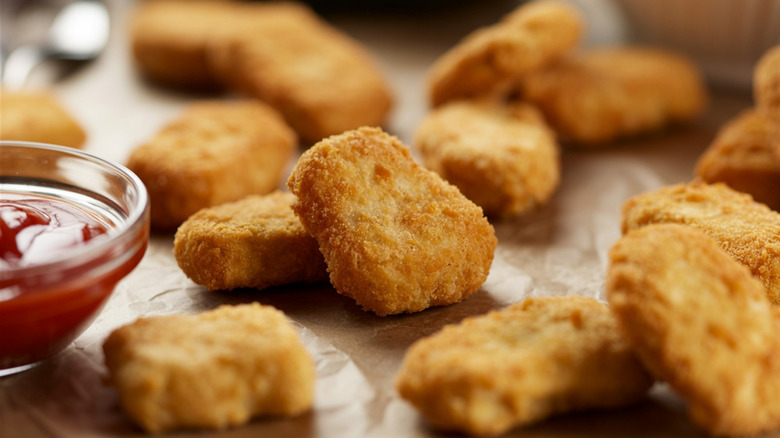 Chicken nuggets next to a ramekin of ketchup