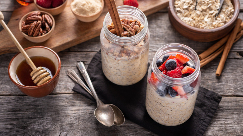 two jars of overnight oats, one with nuts and one with fresh fruit