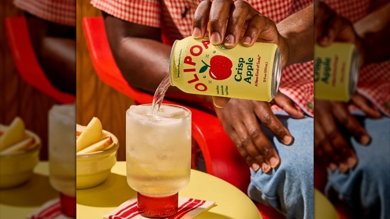 Person pouring a can of Olipop into a glass.