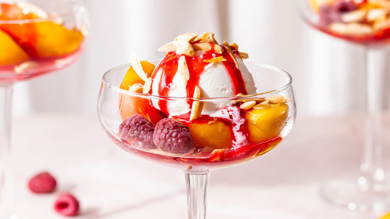Peach melba dessert in a coupe glass