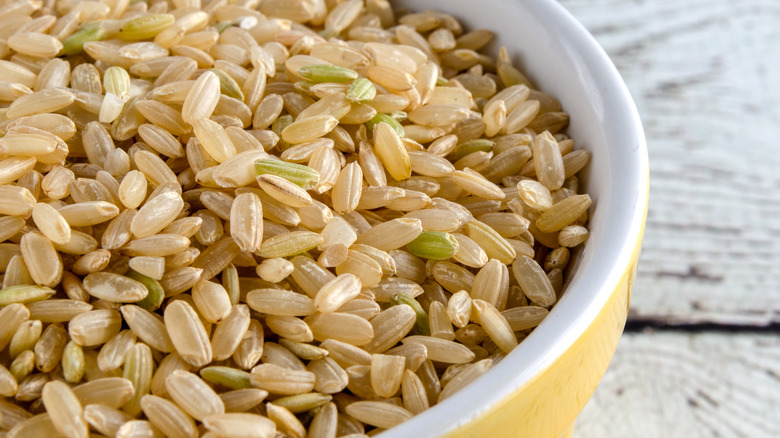 Raw brown rice with green kernels in bowl