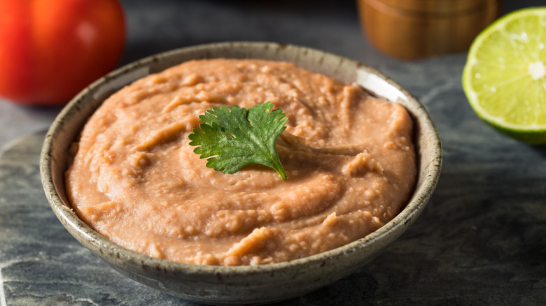 Refried beans in a stoneware bowl.