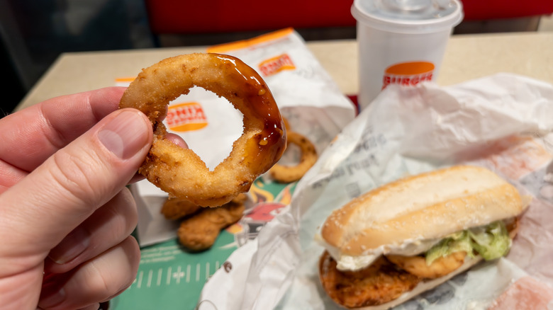 Burger King onion ring held in hand.