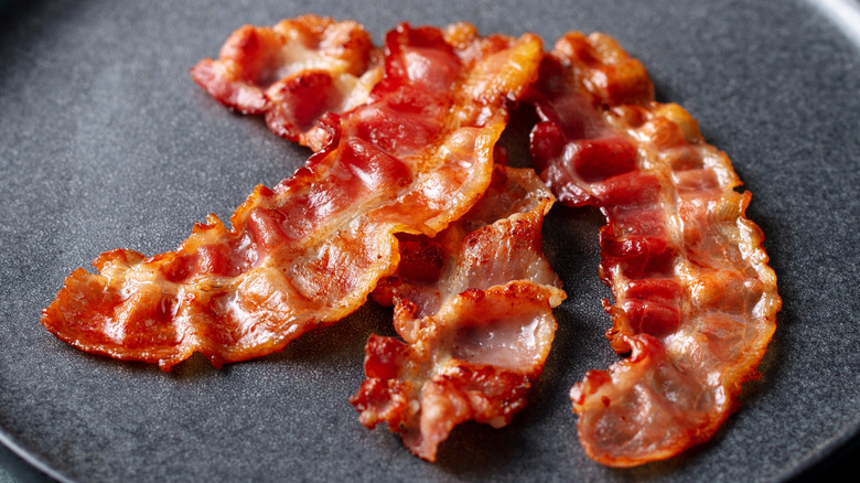 Close-up of fried bacon on a black plate