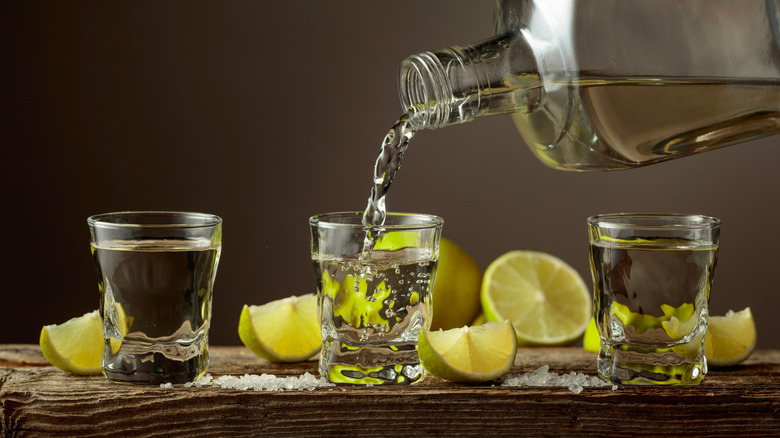 Pouring shots of tequila with limes